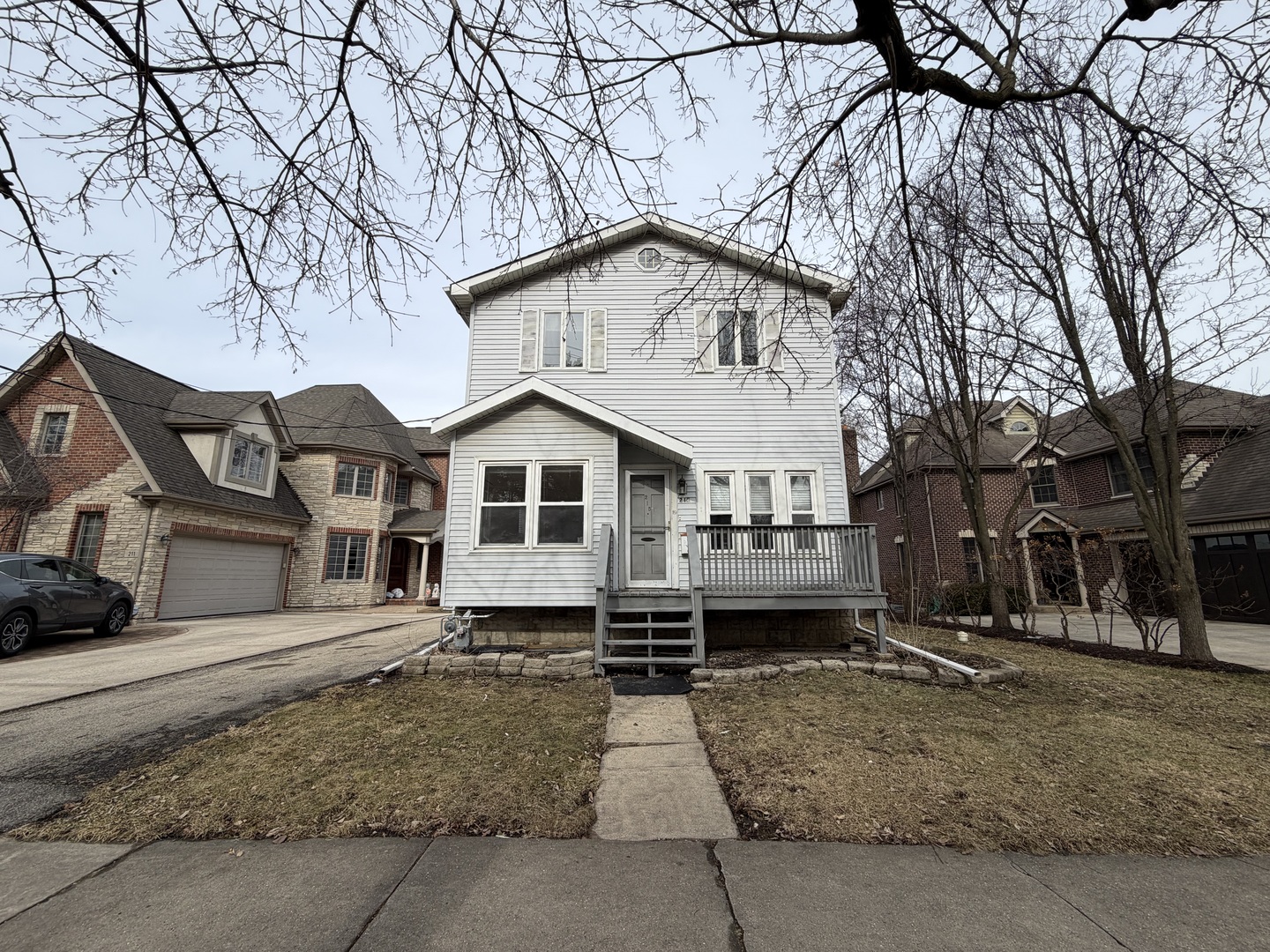 215 Fuller Road Hinsdale, IL 60521 - Photo 1 of 10 a view of a white house with a yard covered in snow