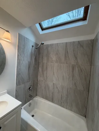 a bathroom with a bathtub a sink and a shower