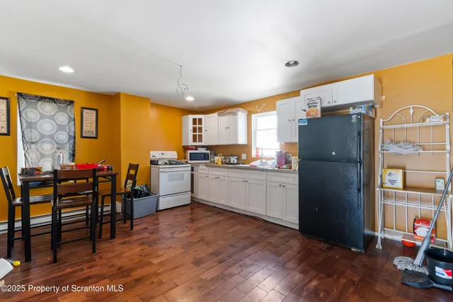 a kitchen with stainless steel appliances wooden cabinets and dining table view
