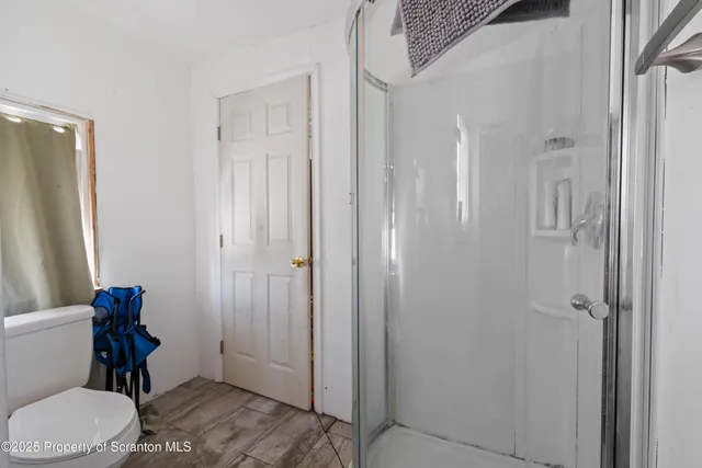 a bathroom with a toilet and a shower