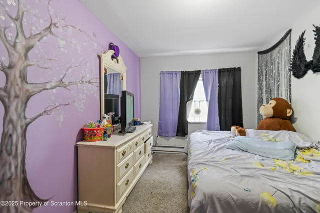 a bedroom with a bed and dresser with mirror