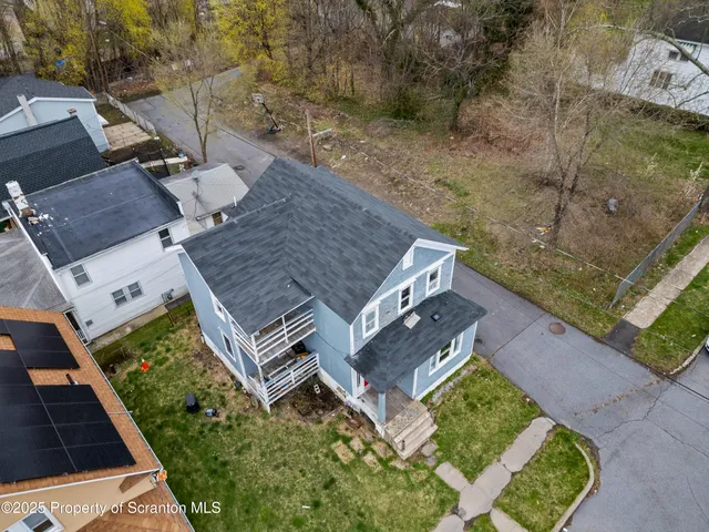 an aerial view of a house with a yard
