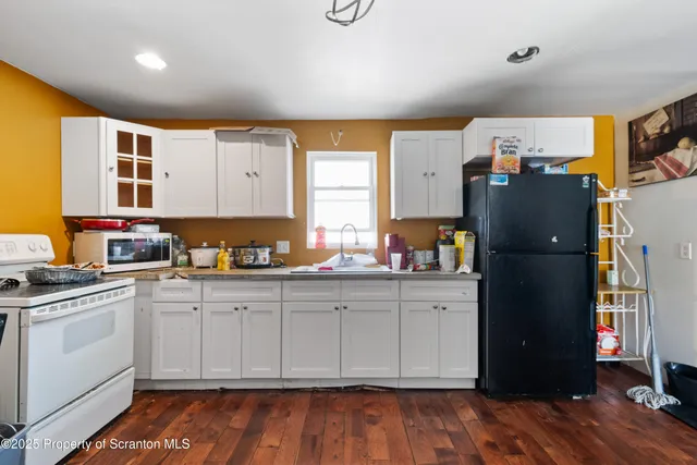 a kitchen with stainless steel appliances granite countertop a refrigerator and a stove top oven