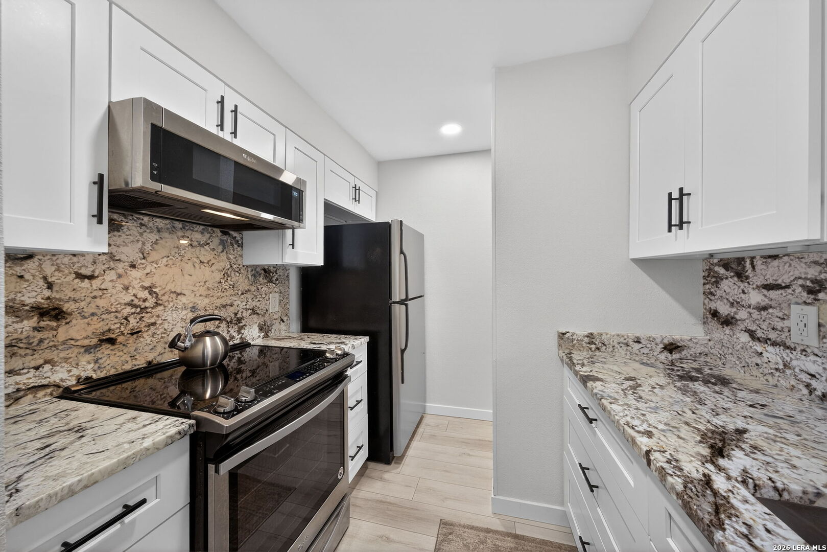 11520 Huebner Road, Unit 501 San Antonio, TX 78230 - Photo 16 of 27 a kitchen with granite countertop a sink and stainless steel appliances