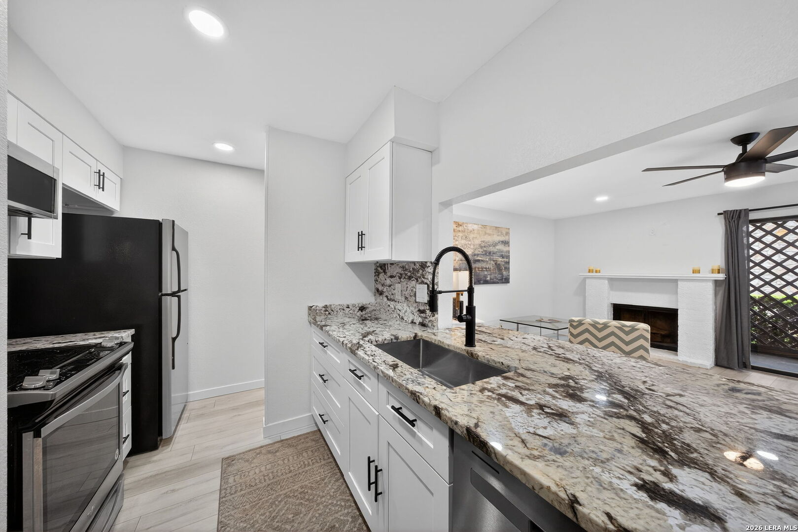 11520 Huebner Road, Unit 501 San Antonio, TX 78230 - Photo 18 of 27 a kitchen with granite countertop a sink stainless steel appliances and white cabinets