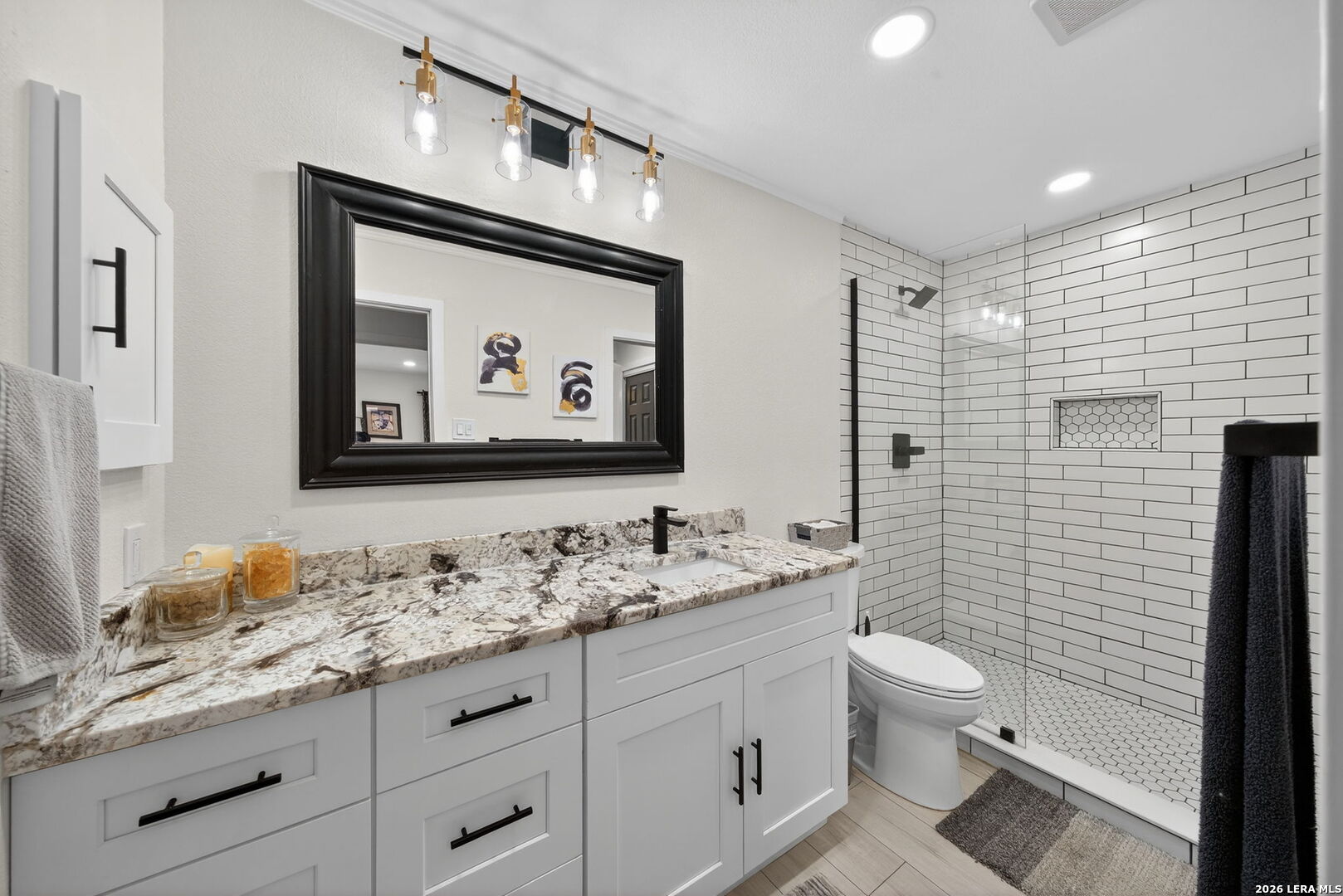 11520 Huebner Road, Unit 501 San Antonio, TX 78230 - Photo 4 of 27 a bathroom with a granite countertop toilet sink and mirror