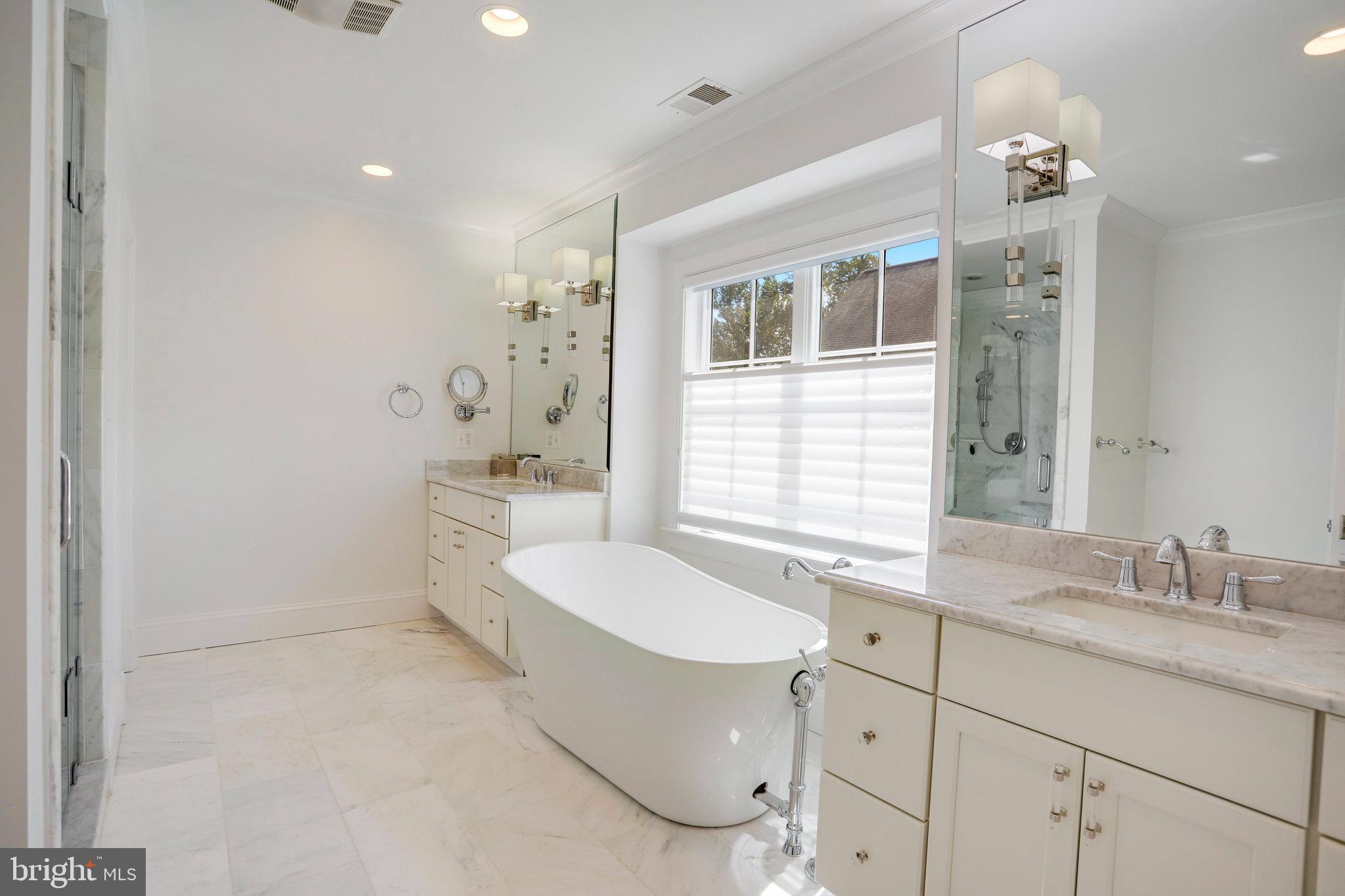 4548 Windsor Lane Bethesda, MD 20814 - Photo 12 of 39 a spacious bathroom with a double vanity sink a mirror and a bathtub
