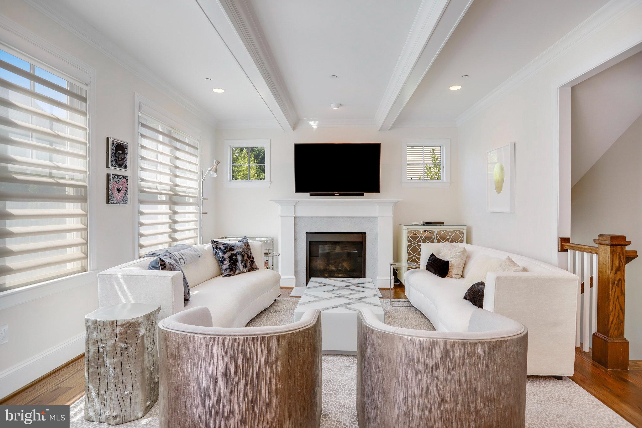 4548 Windsor Lane Bethesda, MD 20814 - Photo 2 of 39 a living room with furniture a flat screen tv and a fireplace