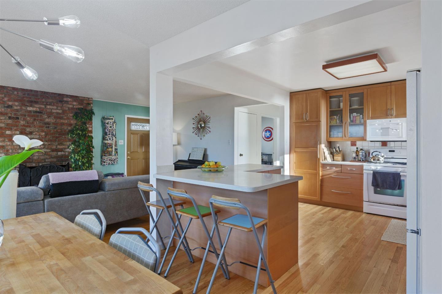 107 Crestmoor Circle Pacifica, CA 94044 - Photo 20 of 45 a kitchen with stainless steel appliances kitchen island granite countertop a stove a refrigerator a sink dishwasher a dining table and chairs with wooden floor