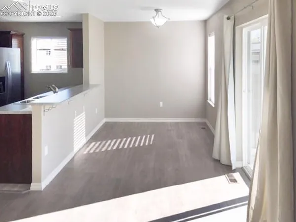 a view of a hallway to a bedroom with windows