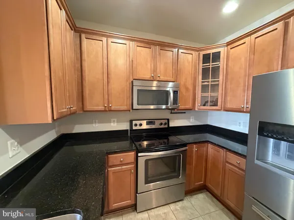 a kitchen with granite countertop a stove and a microwave