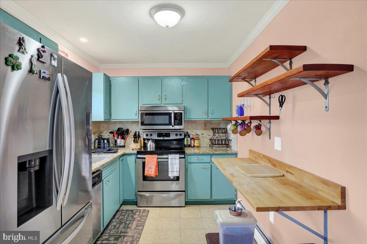 919 Philadelphia Avenue Reading, PA 19607 - Photo 14 of 37 a kitchen with stainless steel appliances kitchen island granite countertop a refrigerator and microwave