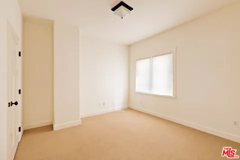 an empty room with a window and ceiling fan
