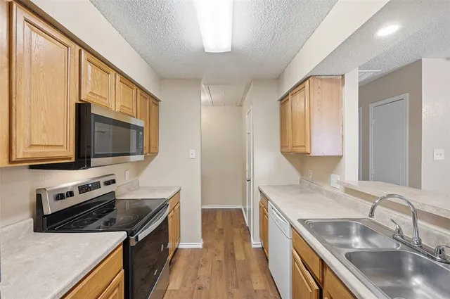 a kitchen with stainless steel appliances granite countertop a sink stove and microwave