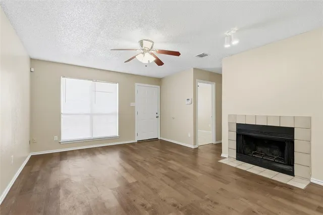 a view of empty room with wooden floor and fireplace