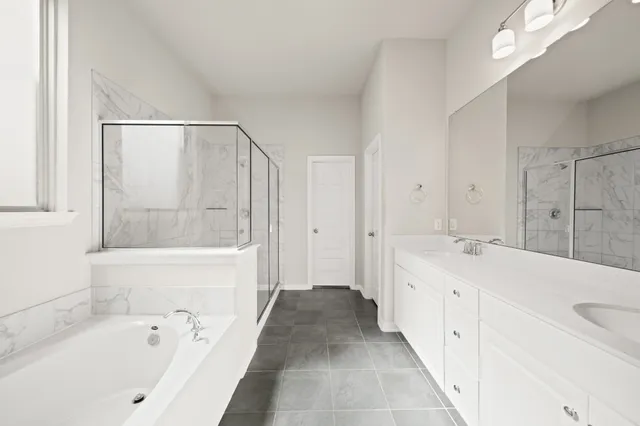 a spacious bathroom with a tub sink and mirror