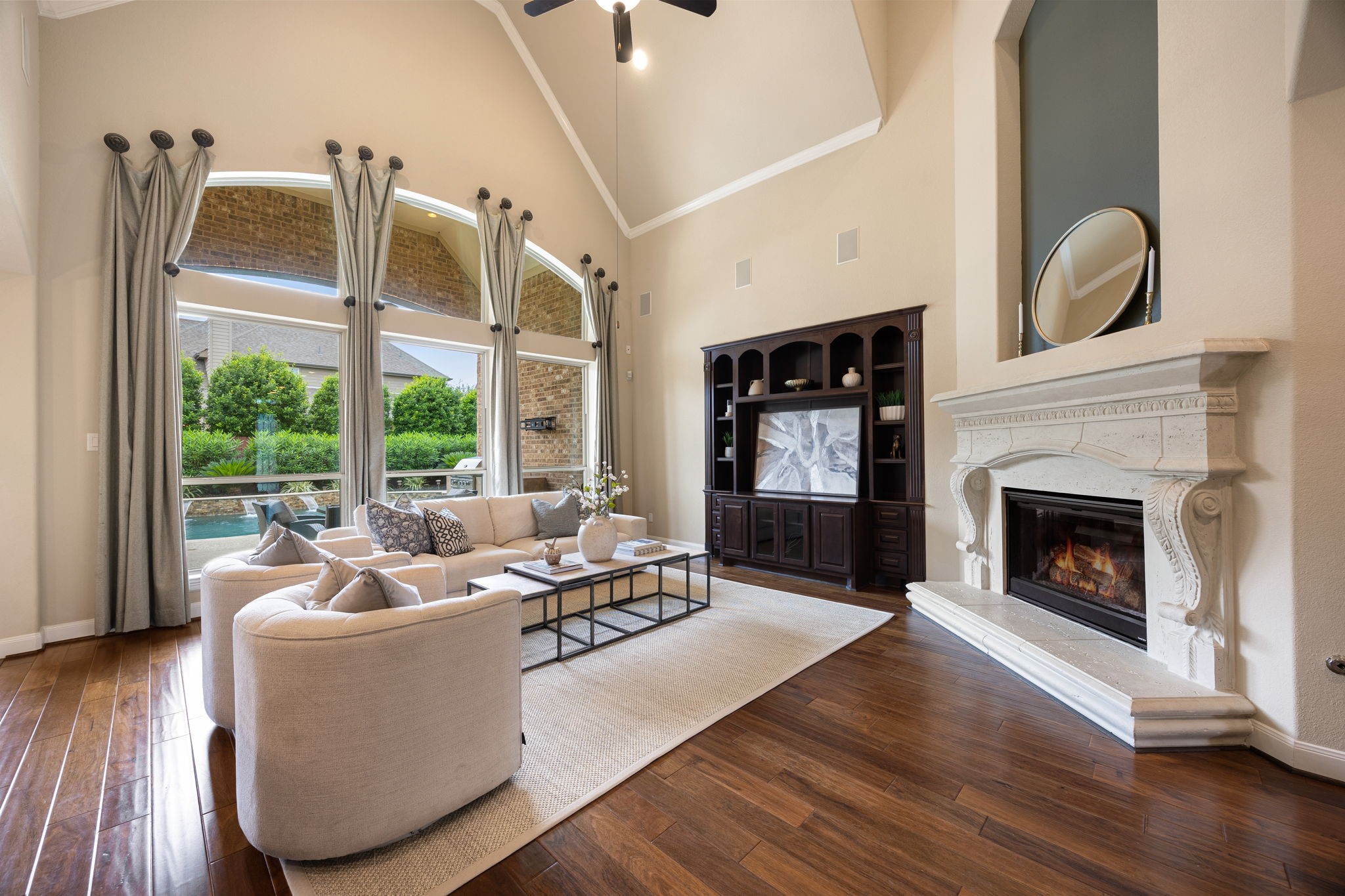 3306 Reston Landing Lane Katy, TX 77494 - Photo 12 of 50 The living area features vaulted ceilings, custom built-in, and a striking caststone fireplace, with expansive windows overlooking the serene backyard retreat.