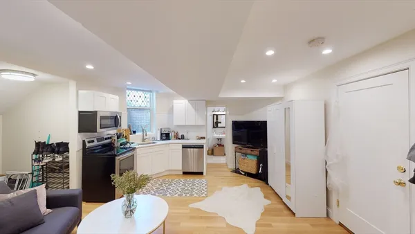 a living room with stainless steel appliances furniture a kitchen view living room and a couch