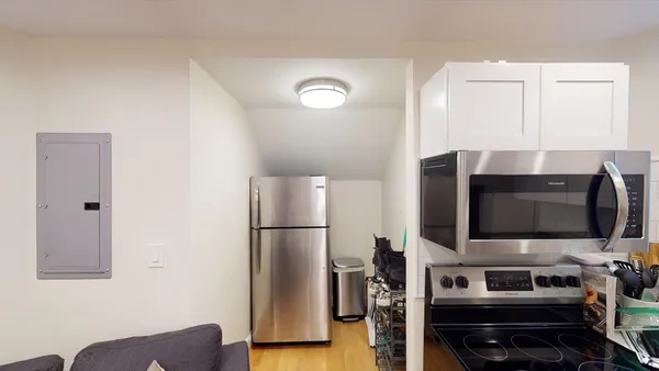 a living room with stainless steel appliances furniture a fireplace and a flat screen tv