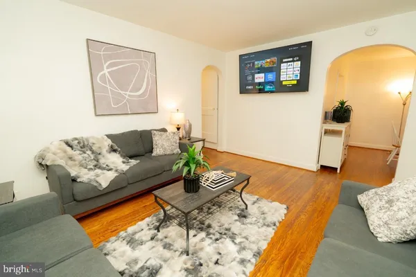 a living room with furniture and a wooden floor