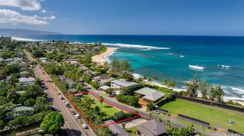 an aerial view of a city with lots of residential buildings ocean and mountain view in back