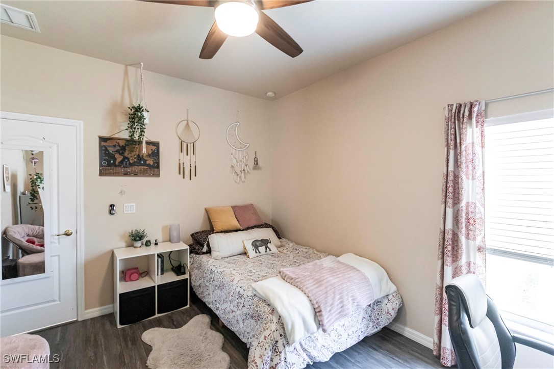 2808 Via Piazza Loop Fort Myers, FL 33905 - Photo 24 of 49 a bedroom with a bed and wooden floor