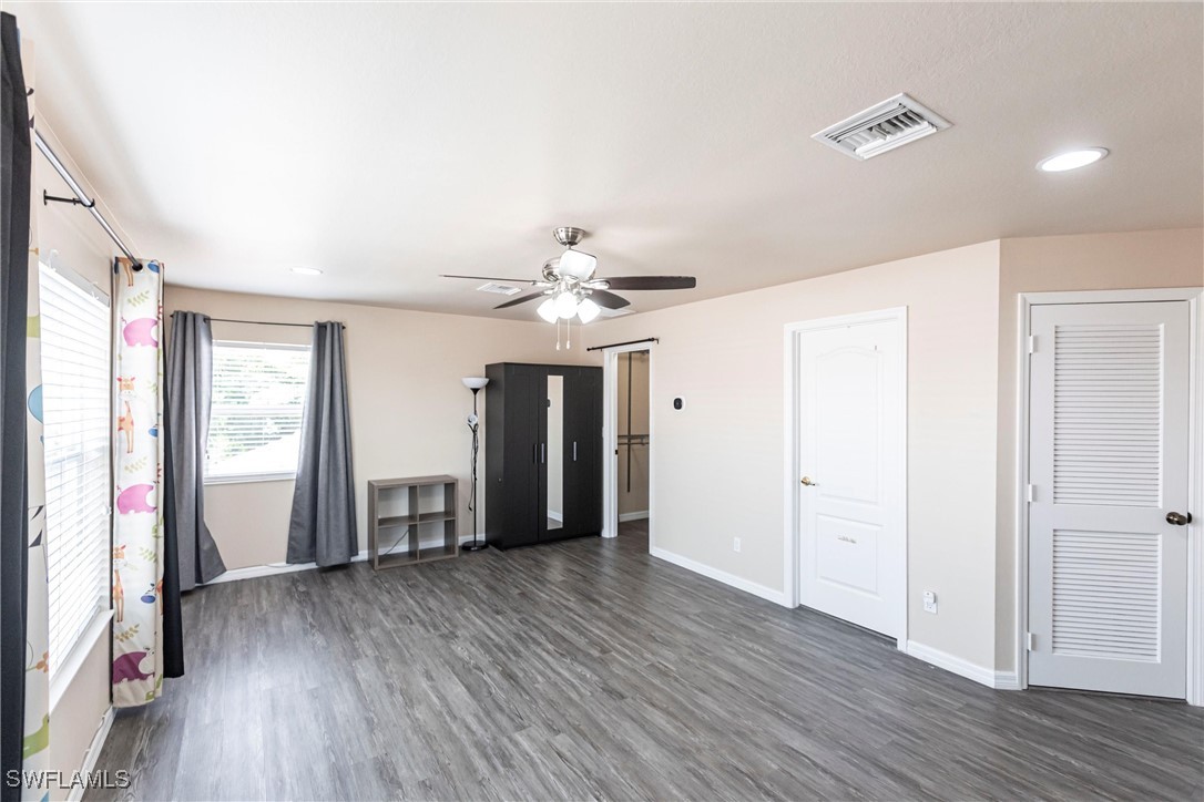 2808 Via Piazza Loop Fort Myers, FL 33905 - Photo 30 of 49 an empty room with wooden floor and windows