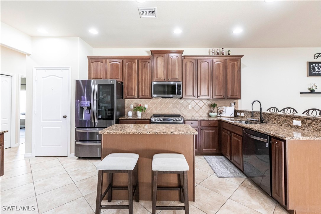2808 Via Piazza Loop Fort Myers, FL 33905 - Photo 8 of 49 a kitchen with stainless steel appliances granite countertop a stove refrigerator sink and cabinets