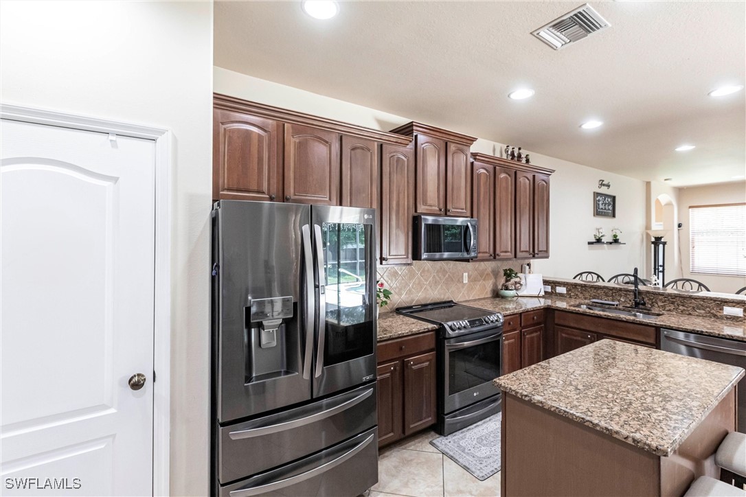 2808 Via Piazza Loop Fort Myers, FL 33905 - Photo 9 of 49 a kitchen with granite countertop stainless steel appliances and wooden cabinets