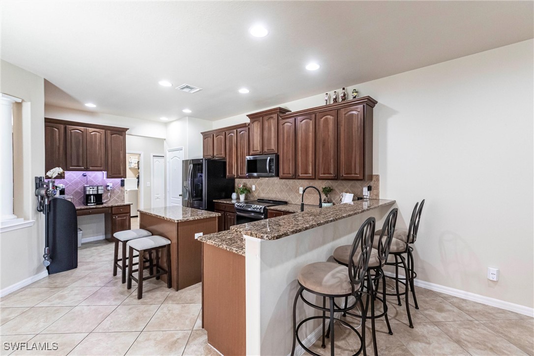 2808 Via Piazza Loop Fort Myers, FL 33905 - Photo 10 of 49 a kitchen with granite countertop sink cabinets and stainless steel appliances