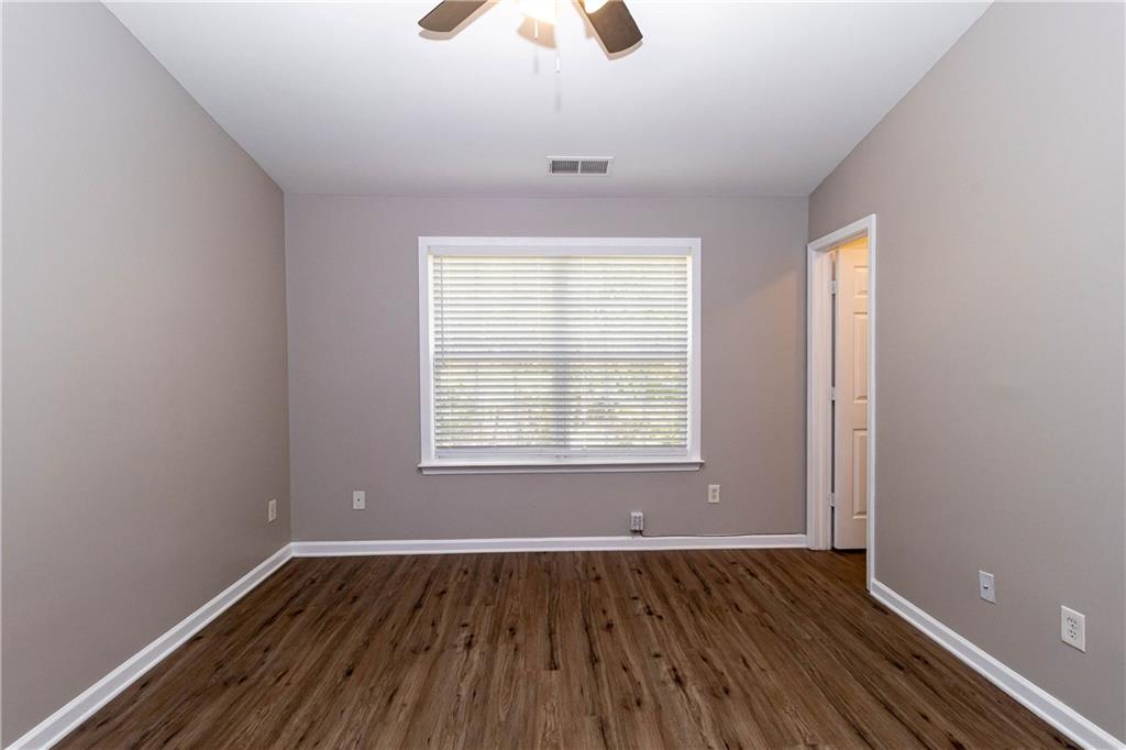745 Crestwell Circle Atlanta, GA 30331 - Photo 23 of 38 an empty room with wooden floor chandelier fan and windows