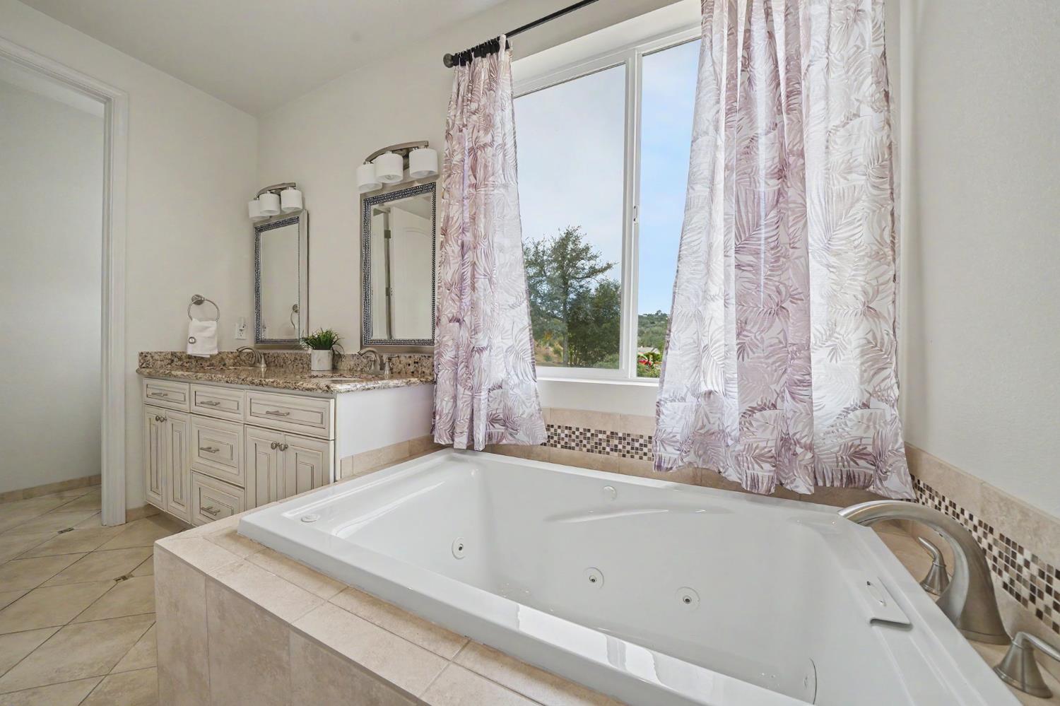 6066 Bluff View Road Copperopolis, CA 95228 - Photo 49 of 96 a bathroom with a tub sink and mirror
