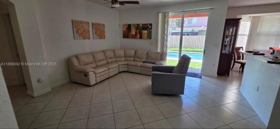 16448 Southwest 67th Terrace Miami, FL 33193 - Photo 11 of 54 a living room with furniture and a floor to ceiling window