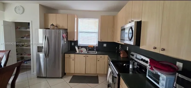 a kitchen with a refrigerator and table chair