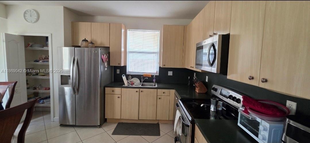 16448 Southwest 67th Terrace Miami, FL 33193 - Photo 12 of 54 a kitchen with stainless steel appliances a refrigerator and a stove top oven
