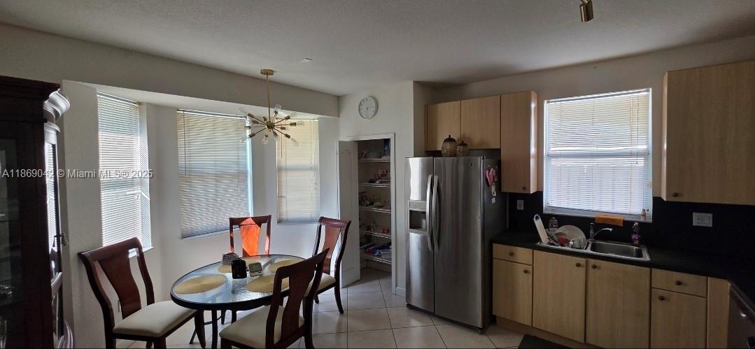 16448 Southwest 67th Terrace Miami, FL 33193 - Photo 14 of 54 a kitchen with stainless steel appliances a dining table chairs and refrigerator