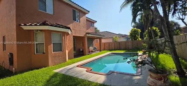 a view of a backyard with brick wall and plants