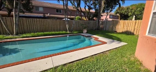a view of a house with backyard and wooden fence