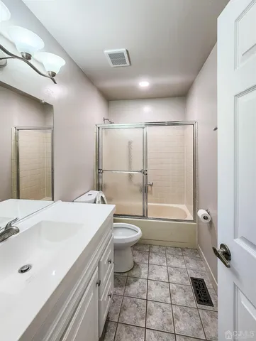 a bathroom with a double vanity sink toilet mirror and bathtub