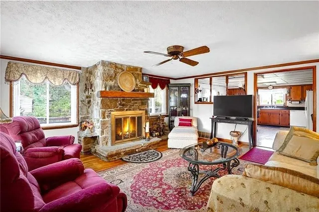 a living room with furniture a fireplace and windows