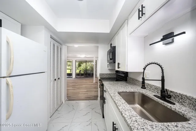 a kitchen with a refrigerator sink and cabinets