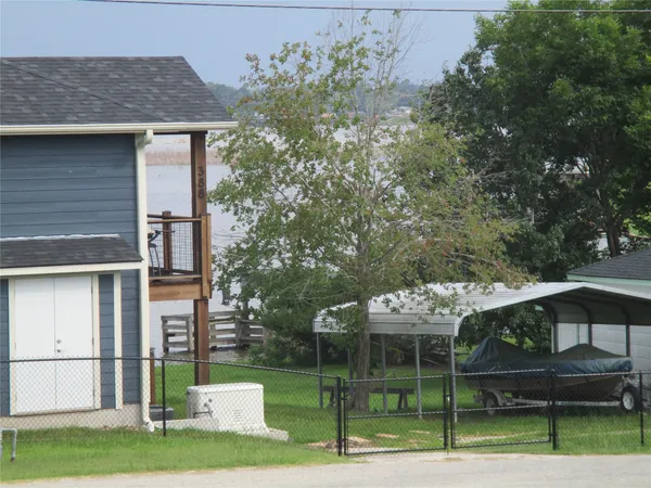 a view of a house with a big yard and a large trees