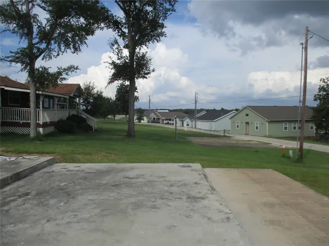 a view of a house with a big yard and palm trees
