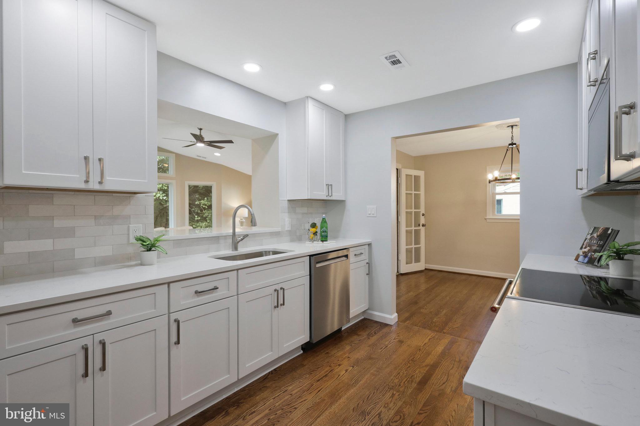 2342 Barbour Road Falls Church, VA 22043 - Photo 5 of 30 a kitchen with a sink dishwasher and white cabinets with wooden floor