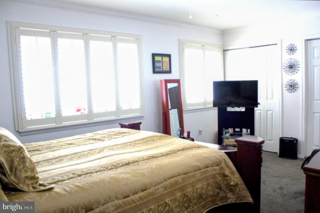 1902 Valley Terrace Southeast Washington, DC 20032 - Photo 21 of 38 a bedroom with a bed and a flat tv screen next to a window