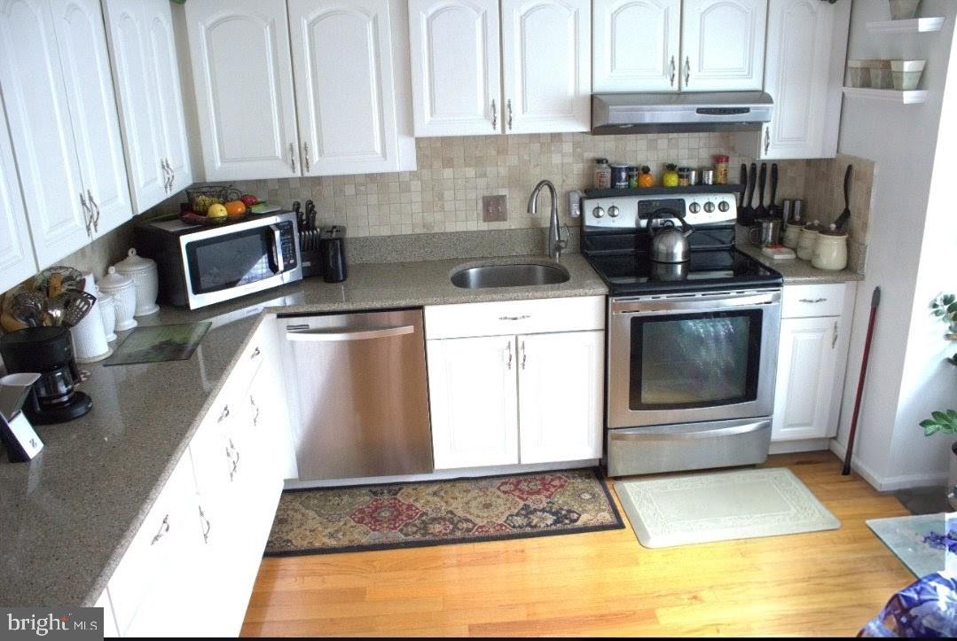 1902 Valley Terrace Southeast Washington, DC 20032 - Photo 4 of 38 a kitchen with granite countertop a stove a sink and a microwave