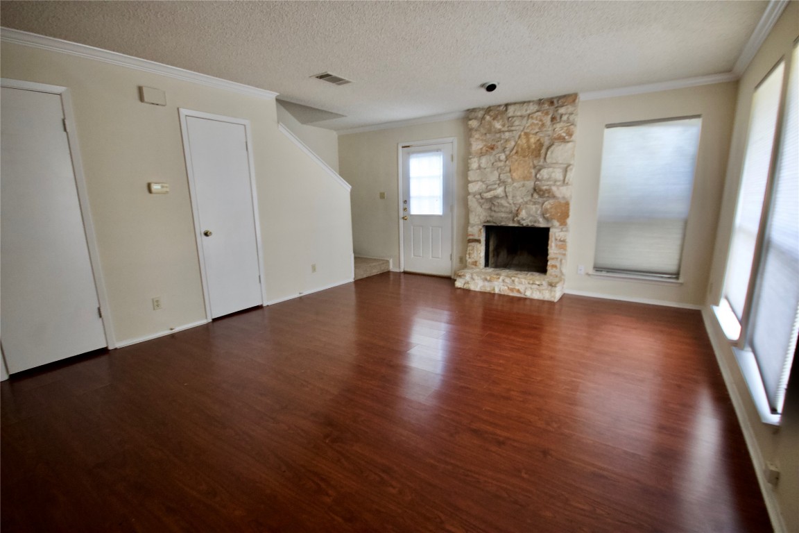 1405 D Camp Craft Road, Unit D West Lake Hills, TX 78746 - Photo 4 of 10 an empty room with wooden floor fireplace and windows