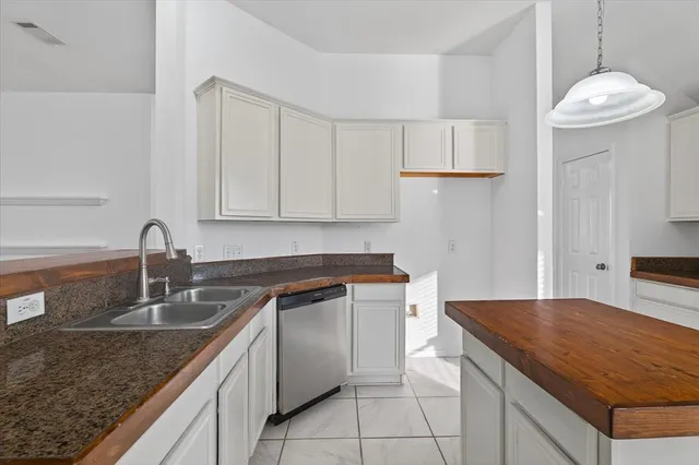 a kitchen with a sink dishwasher and cabinets