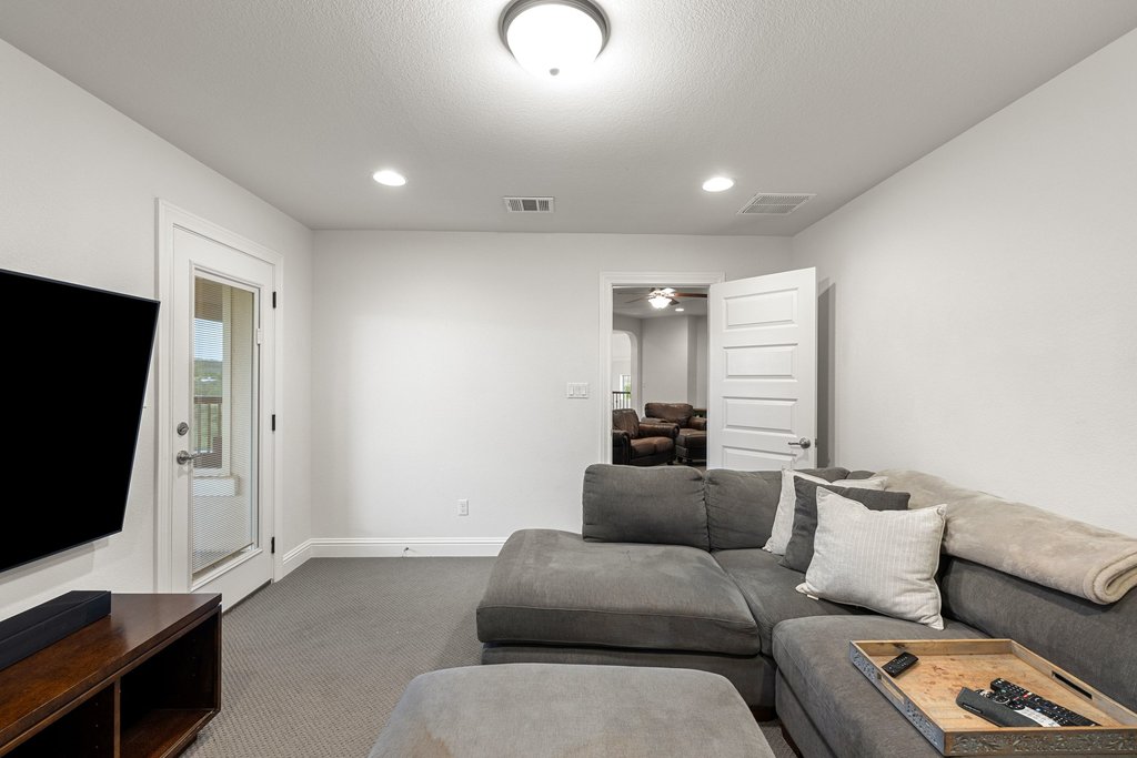 215 Lodestone Lane Austin, TX 78738 - Photo 27 of 40 Step into this media room featuring plush carpeting and convenient outdoor access to the private balcony.