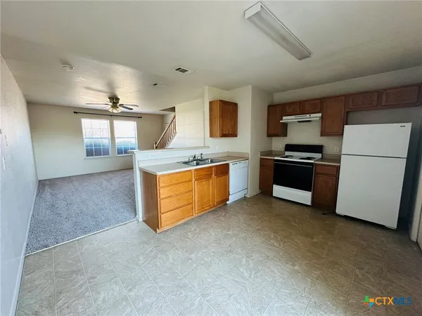 a kitchen with stainless steel appliances granite countertop a stove a sink and a refrigerator